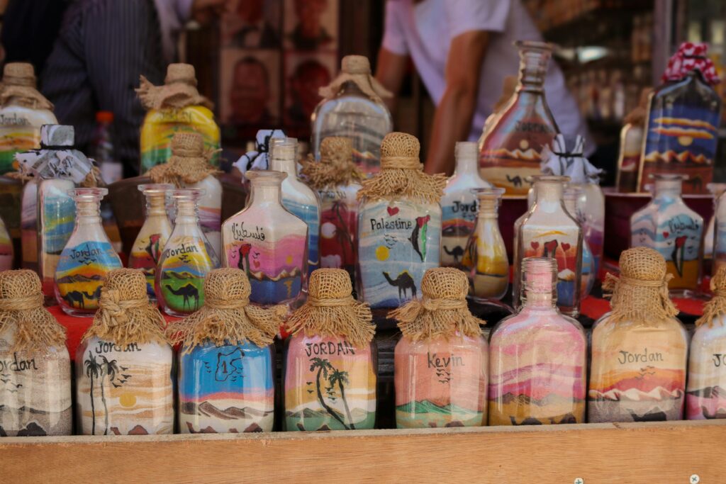 Vibrant sand art bottles displayed in a Jordanian market stall showcasing local culture and souvenirs.